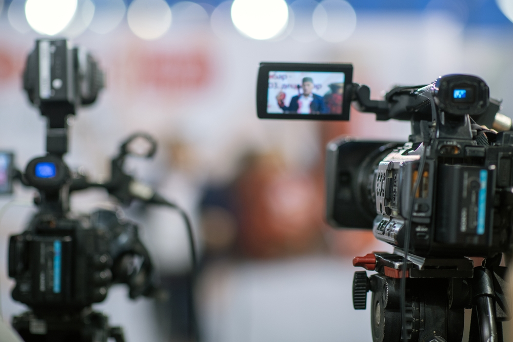 Close,Up,View,Of,A,Camera,Capturing,A,Press,Conference